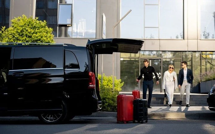 Private transfer vehicle with open trunk and luggage, passengers approaching, Marrakesh to Agadir.
