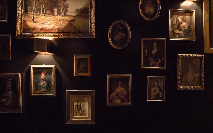 Framed art on dimly lit wall at historic Roman theatre in Lisbon.
