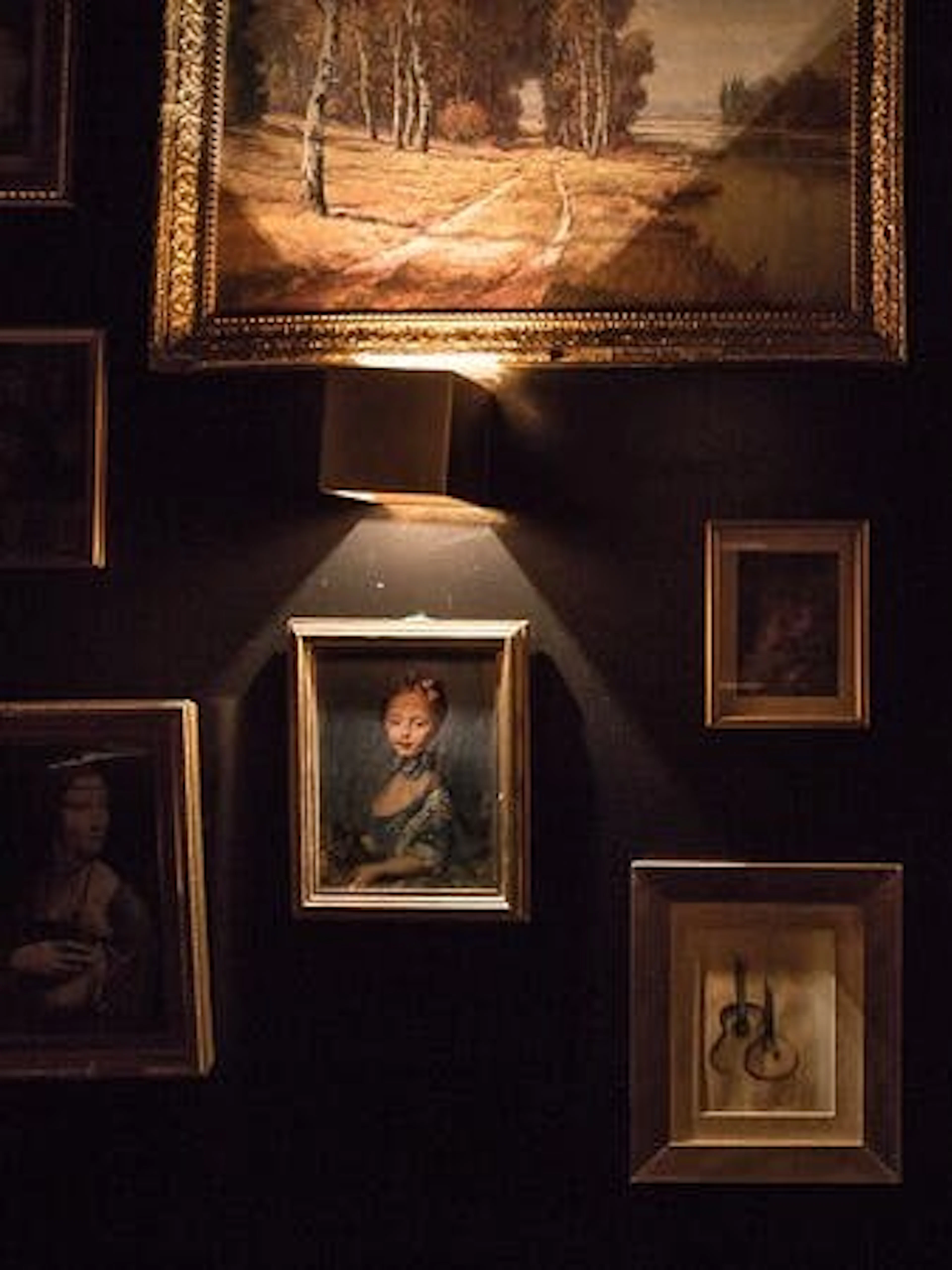Framed art on dimly lit wall at historic Roman theatre in Lisbon.