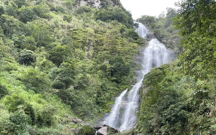 Waterfall surrounded by lush greenery on Sapa Motorbike Tour, Vietnam.