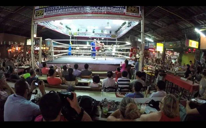 Muay Thai match at Thapae Stadium, Chiang Mai, with audience watching.