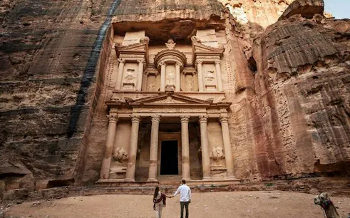 Couple exploring the ancient rock-carved Treasury in Petra during a full-day tour from Sharm El Sheikh.