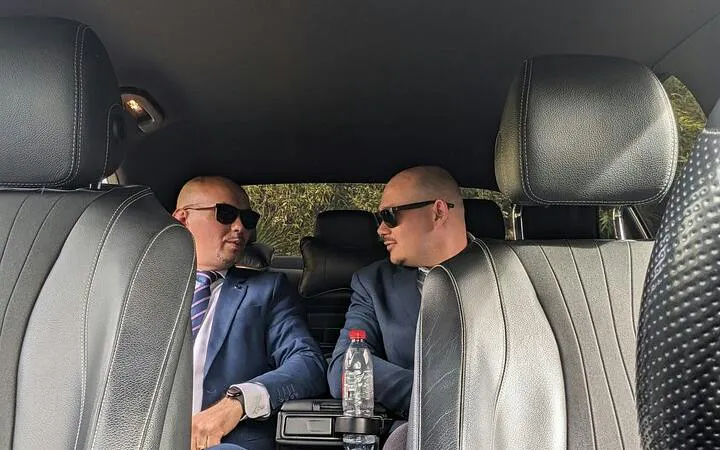 Private car interior with two drivers in suits for Bucharest Otopeni Airport transfer.