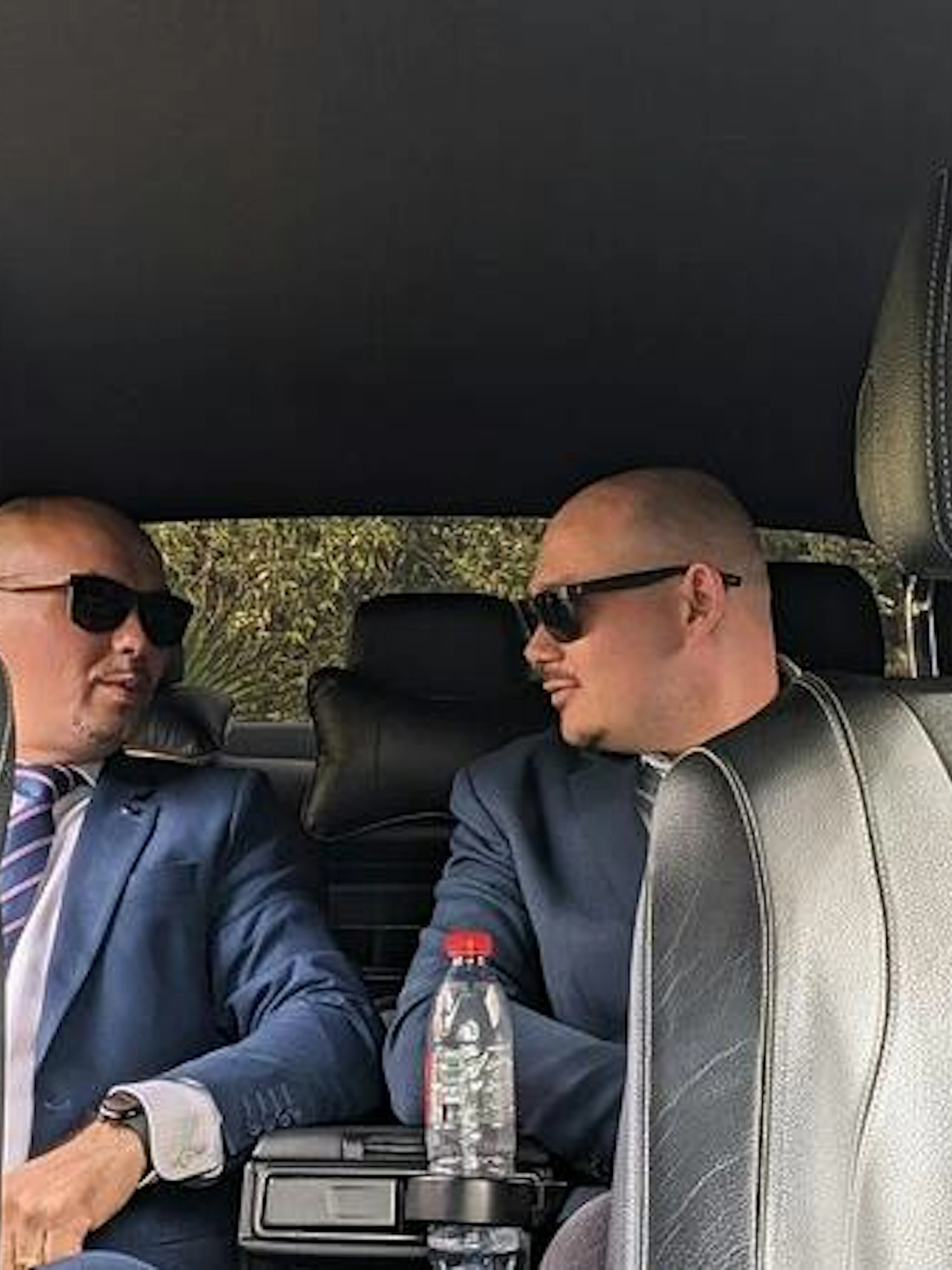 Private car interior with two drivers in suits for Bucharest Otopeni Airport transfer.