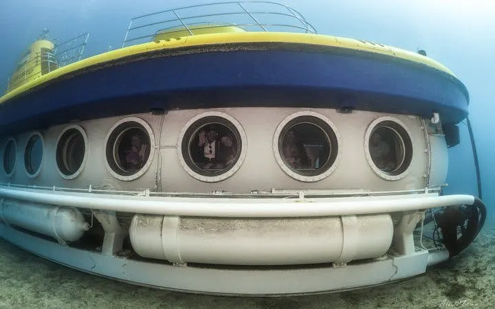 Submarine underwater in Tenerife with visible portholes, part of Los Gigantes tour.