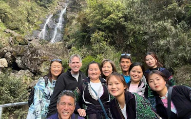 Group of tourists at a waterfall in Sapa during a private car tour to Lonely Tree and Heaven's Gate.