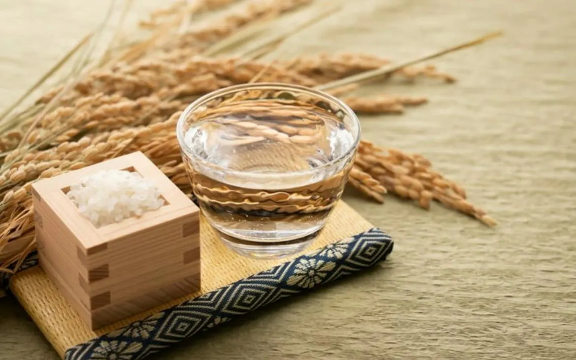 Sake glass and rice grains on a mat, Kyoto Sake Tasting experience.
