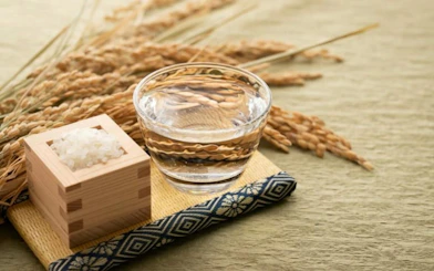 Sake glass and rice grains on a mat, Kyoto Sake Tasting experience.