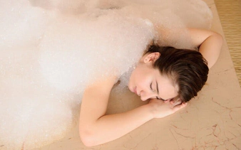 Person relaxing under foam during Turkish bath in Sharm El Sheikh spa.