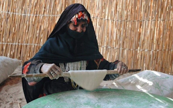 Local woman making traditional bread during desert safari in Sharm El Sheikh.
