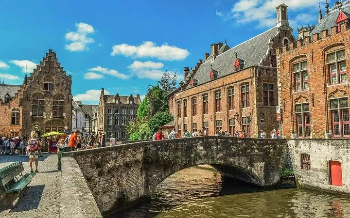 Bridge over canal with historic buildings in Bruges, Belgium, part of day trip from Brussels.