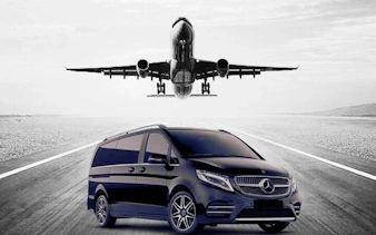 Private transfer van on runway with airplane landing at Antalya Airport.