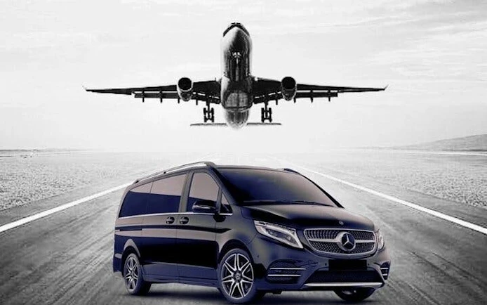 Private transfer van on runway with airplane landing at Antalya Airport.
