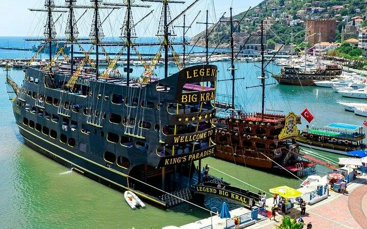 Pirate-themed boat docked in Alanya harbor, offering tours with free drinks.