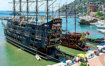 Pirate-themed boat docked in Alanya harbor, offering tours with free drinks.