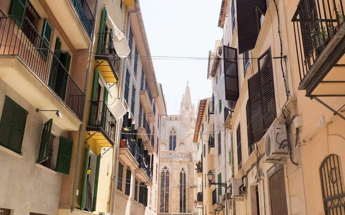 Narrow street view leading to Palma Cathedral, Mallorca, on a sunny day.