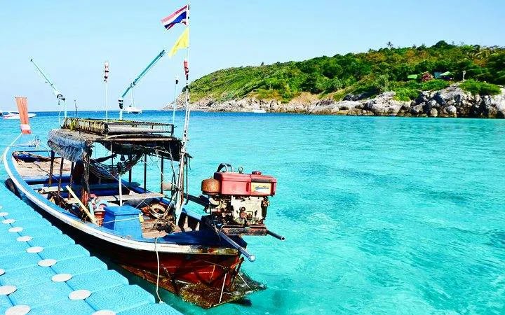 Speedboat docked near Coral Island with clear turquoise water, Phuket.