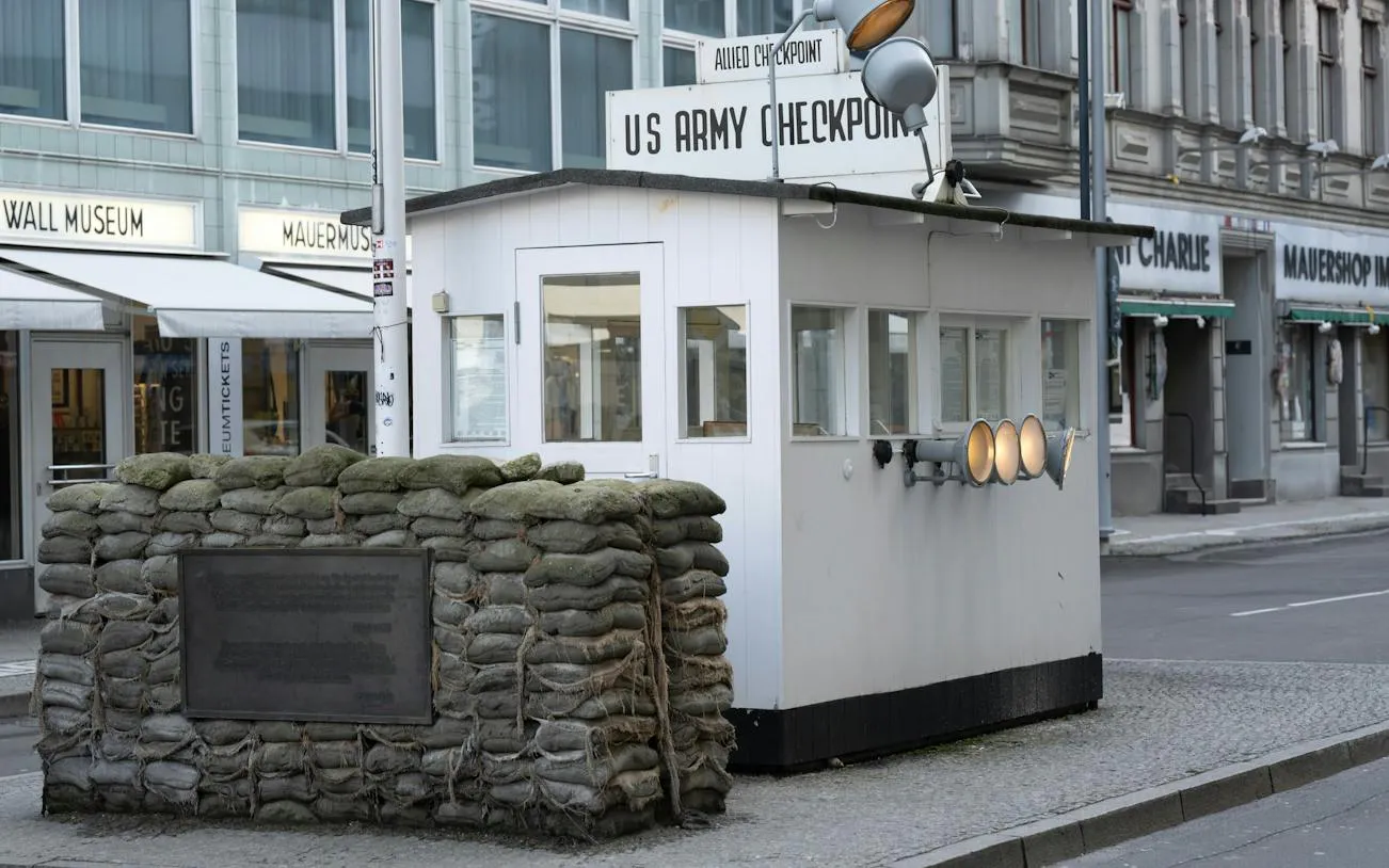 Checkpoint Charlie guardhouse with sandbags, Berlin Wall Museum in background, Berlin.
