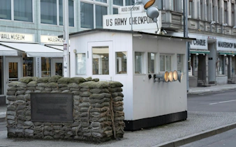 Checkpoint Charlie guardhouse with sandbags, Berlin Wall Museum in background, Berlin.