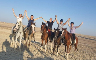 Group horseback riding in Hurghada desert near Red Sea.
