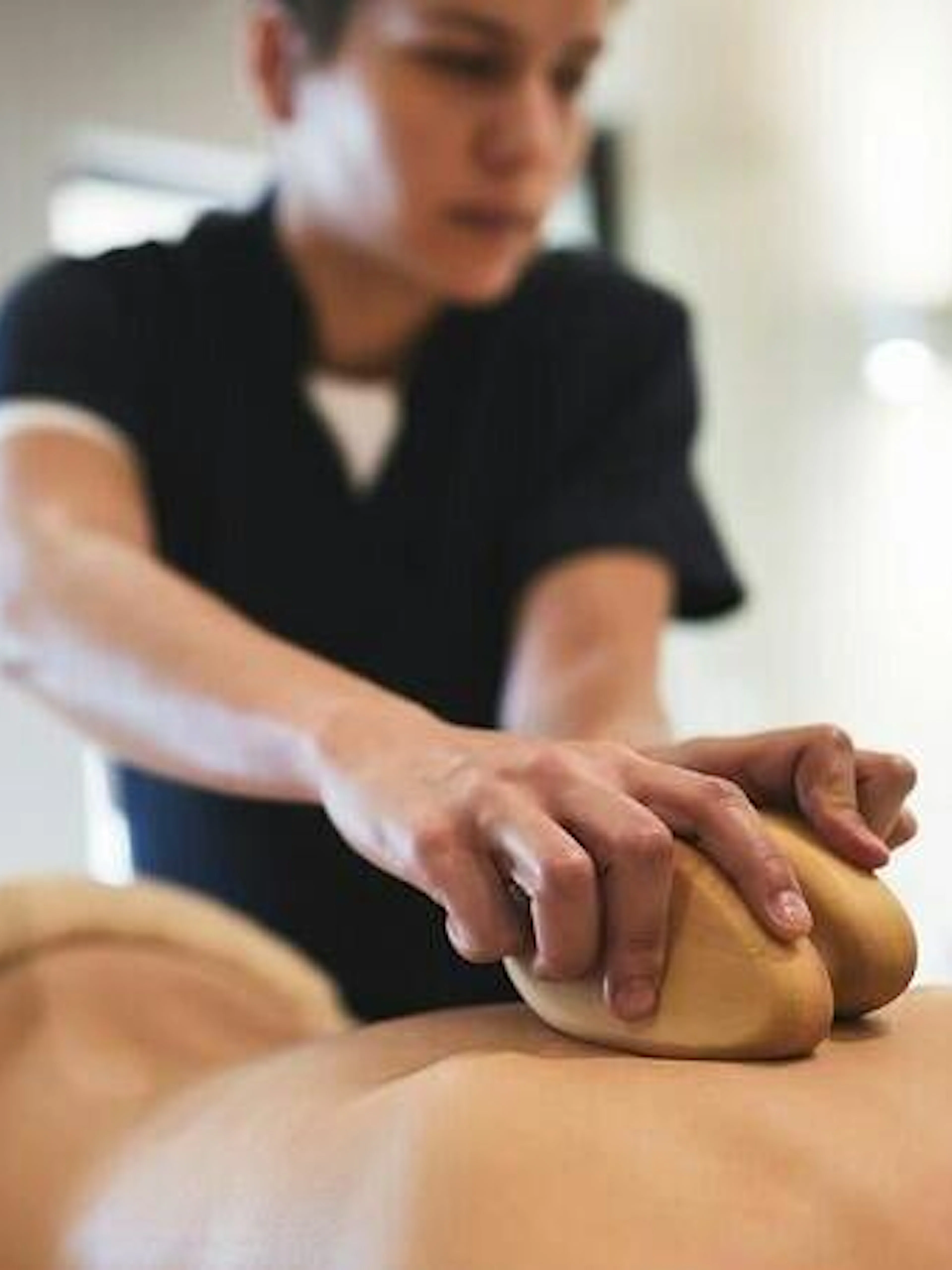 Person receiving a massage with herbal compress in a Moroccan hammam, Marrakesh.