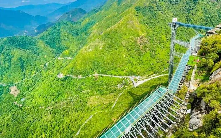 Glass bridge spanning lush green mountains in Sa Pa, Vietnam.