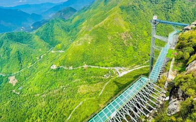 Glass bridge spanning lush green mountains in Sa Pa, Vietnam.