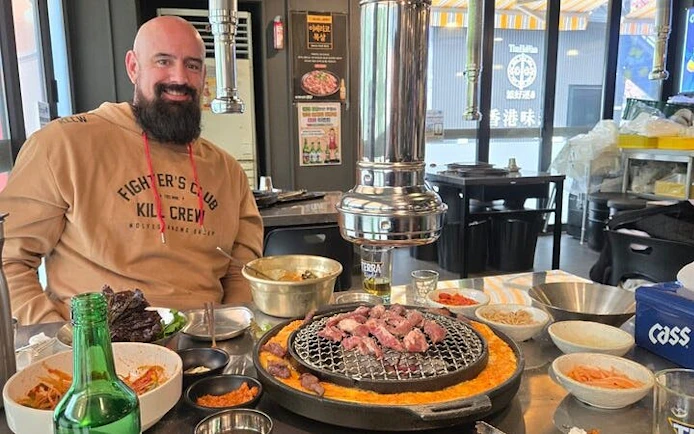 Korean BBQ dinner setup with grilled meat and side dishes in a Seoul restaurant during Gangnam walking tour.