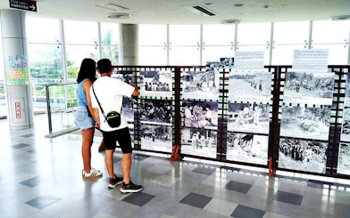 Visitors viewing historical WWII photos at Okinawa Navy Underground HQ in Naha.