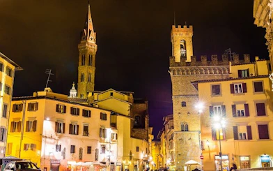 Florence cityscape at night with historic towers and illuminated buildings.
