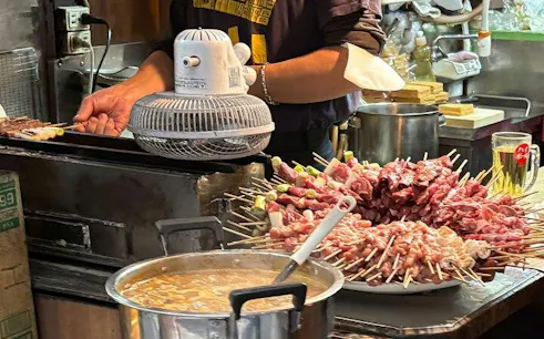 Skewers being grilled at a local eatery in Shinjuku, Tokyo during a guided food tour.