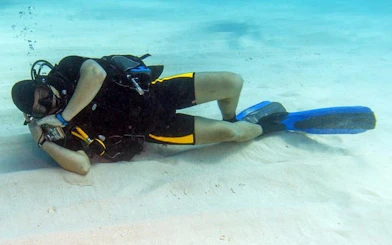 Scuba diver resting on sandy seabed during Hurghada boat trip.