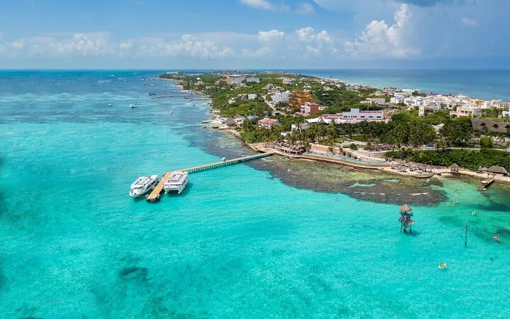 Catamaran docked at Isla Mujeres with turquoise waters and beachfront view.