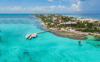 Catamaran docked at Isla Mujeres with turquoise waters and beachfront view.
