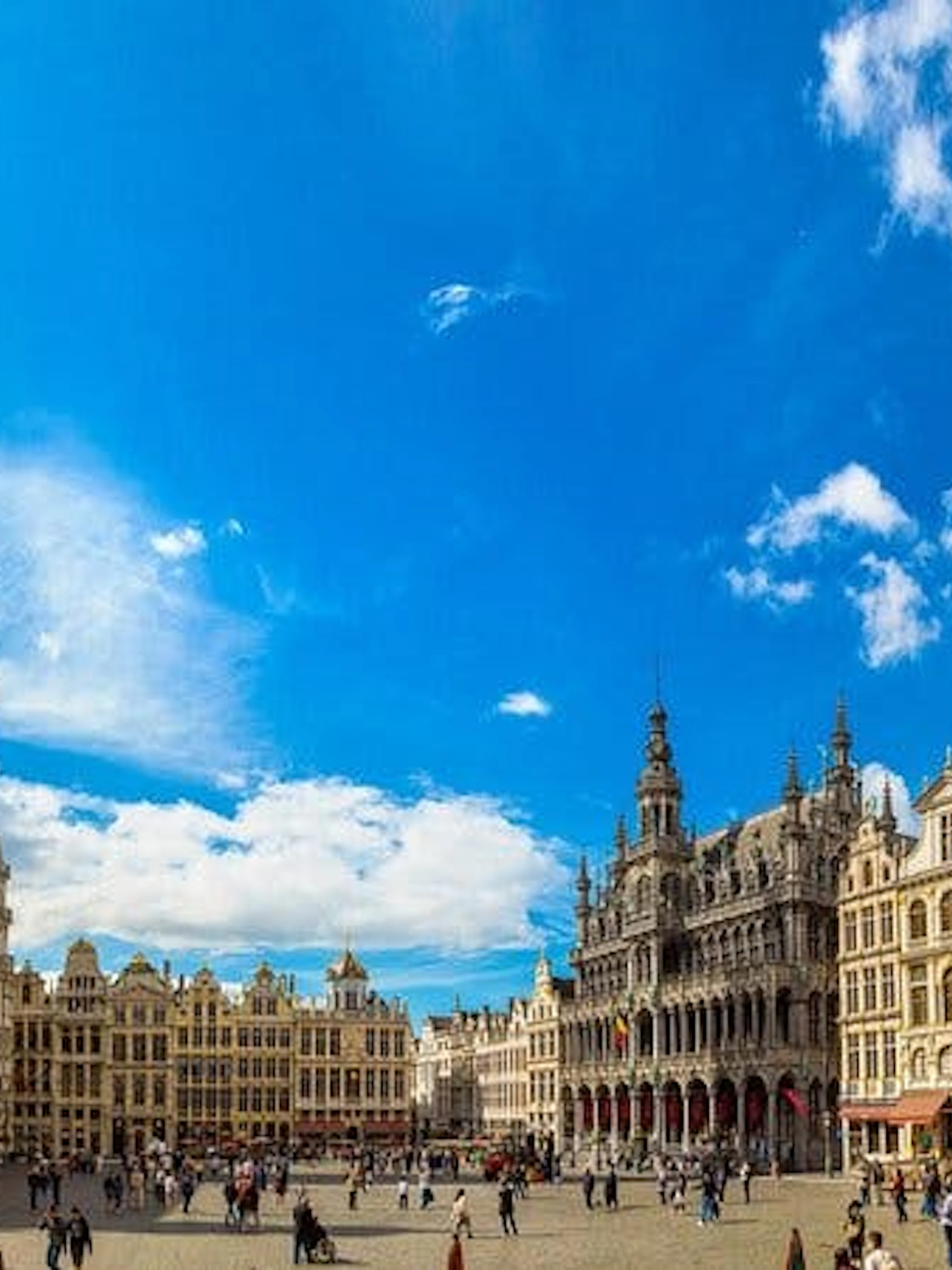 Grand Place in Brussels with historic buildings and tourists exploring the square.