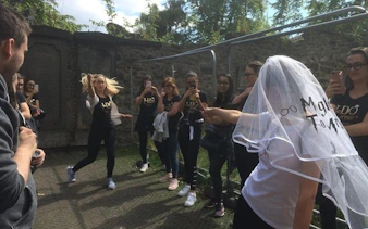 Group enjoying Harry Potter walking tour in Edinburgh cemetery, engaging in trivia and games.