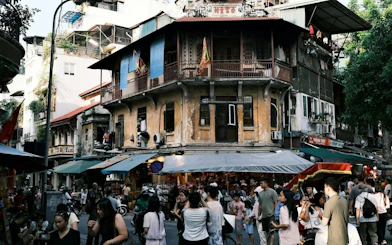 Hanoi Old Quarter street scene with bustling market and historic buildings.