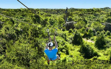 Ziplining over lush forest in Punta Cana, part of the Dominican Village Adventure.