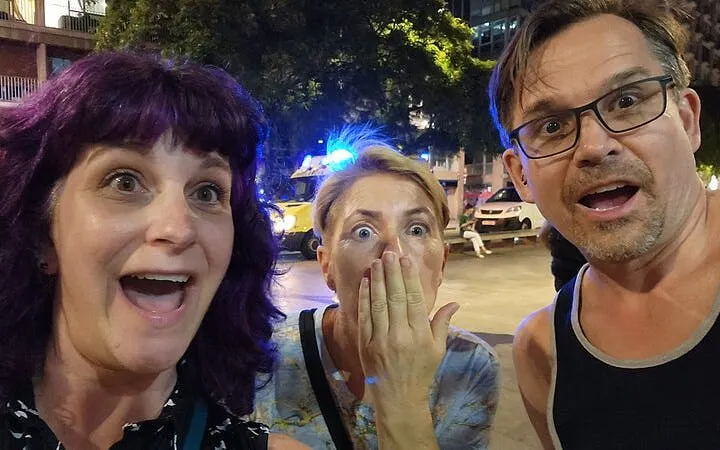 Tourists reacting with surprise during the Ghosts of Gothic Barcelona exploration game at night.