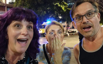 Tourists reacting with surprise during the Ghosts of Gothic Barcelona exploration game at night.