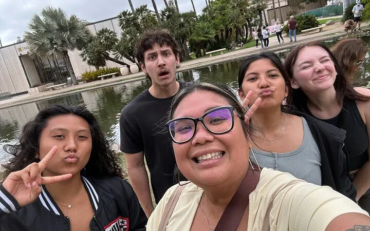 Group enjoying Balboa Park with pond and palm trees in San Diego during self-guided city exploration.