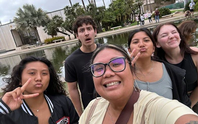 Group enjoying Balboa Park with pond and palm trees in San Diego during self-guided city exploration.