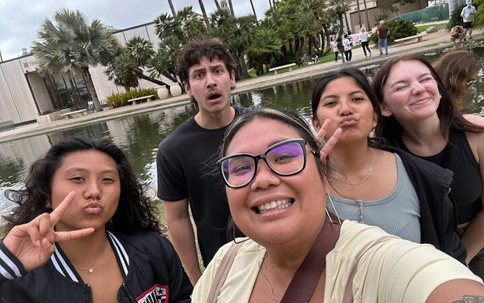 Group enjoying Balboa Park with pond and palm trees in San Diego during self-guided city exploration.