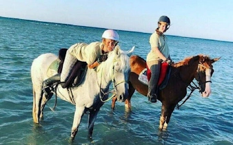Horseback riders in the Red Sea near Hurghada, enjoying a beach and desert tour.