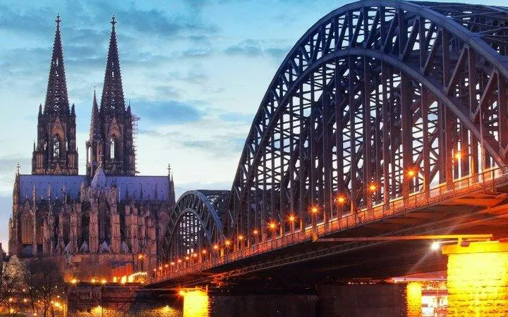 Cologne Cathedral and Hohenzollern Bridge at dusk, part of self-guided walking tour.