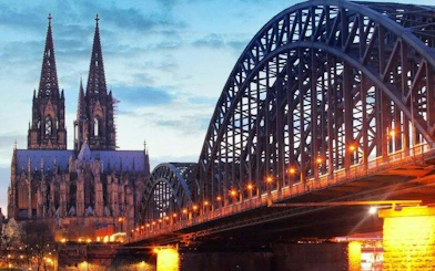 Cologne Cathedral and Hohenzollern Bridge at dusk, part of self-guided walking tour.