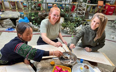 Local artisans and visitors creating batik art with beeswax in Sa Pa workshop.