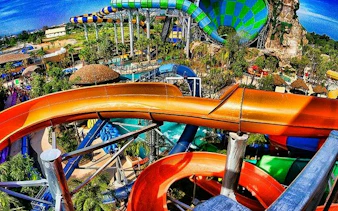 Water slides at Vana Nava Waterpark, Hua Hin, with lush surroundings and vibrant colors.