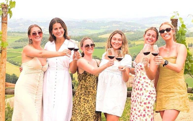 Women enjoying wine tasting in Tuscan vineyard during day trip from Rome.