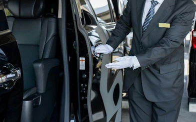 Private car service with driver opening door for Tokyo airport transfer.